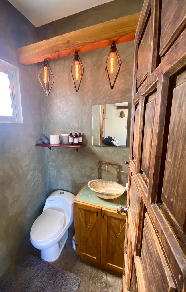 Private bathroom at Casa Xolo with woodwork and warm pendant lights
