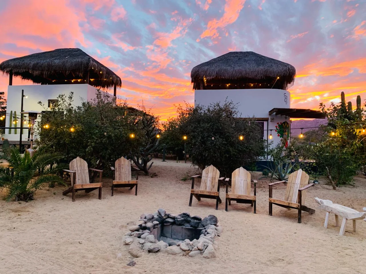 Fire pit and palapa rooms at dusk at Casa Xolo